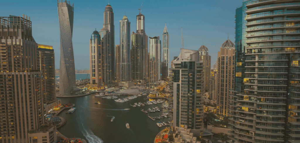 Modern Dubai skyline with skyscrapers and marina at dusk, showcasing luxury accommodations and urban lifestyle.